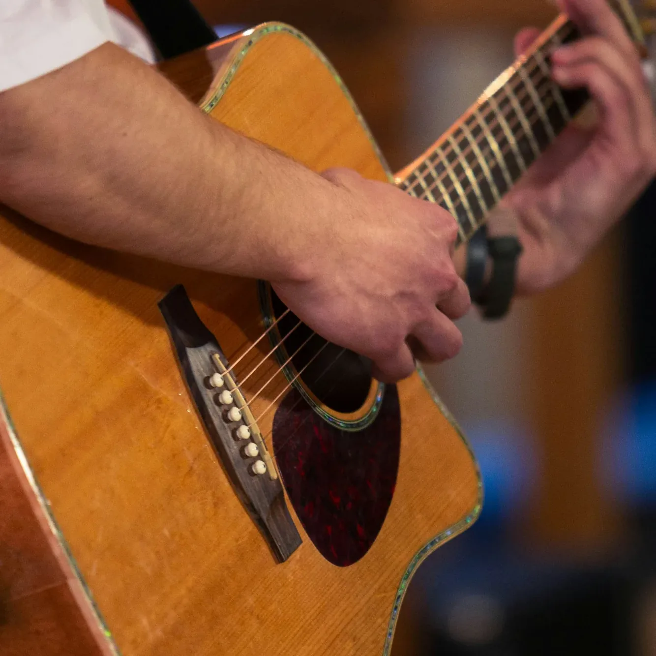 Close-up of a musician's hands playing an acoustic guitar