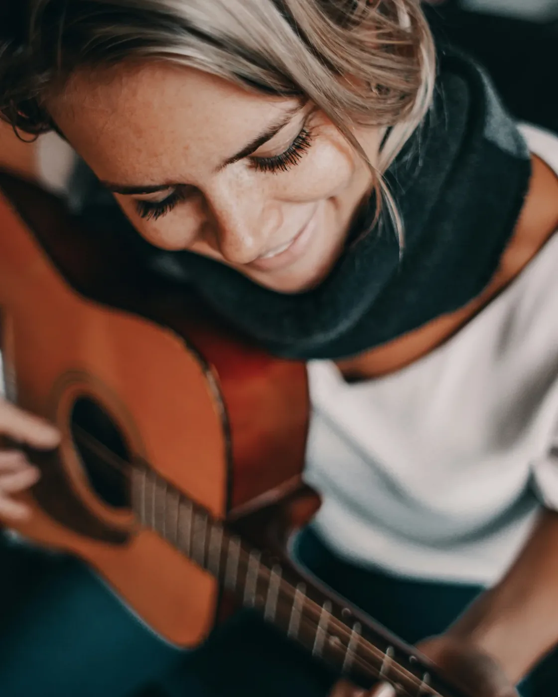 A Hertz2Hearts music facilitator playing an acoustic guitar
