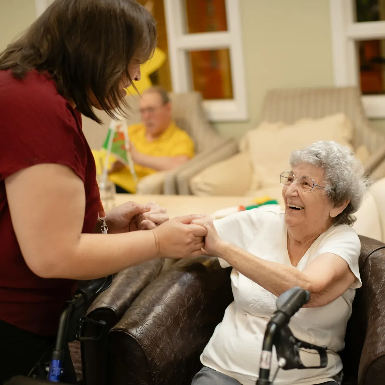 A facilitator holding a resident's hand during a one-to-one session